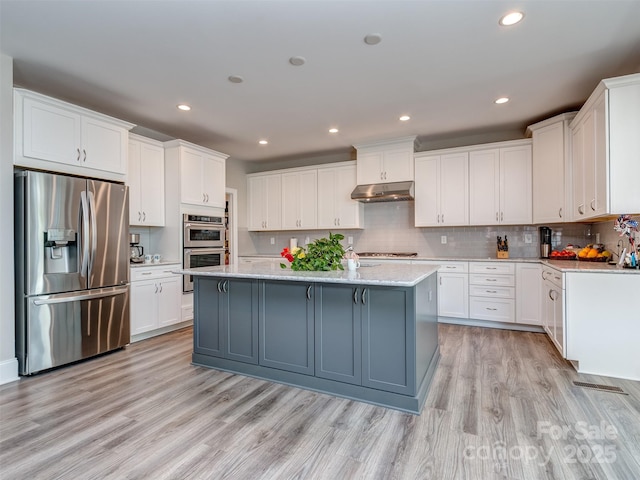 1011 Golden Bell Dr, Waxhaw, NC 28173 - kitchen with stainless steel appliances, white cabinets, light wood-type flooring, under cabinet range hood, and recessed lighting