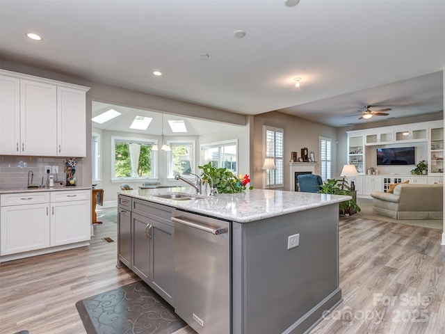 1011 Golden Bell Dr, Waxhaw, NC 28173 - kitchen featuring stainless steel dishwasher, light wood finished floors, a center island with sink, recessed lighting, and white cabinets