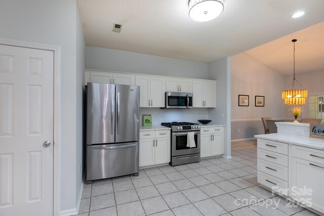 6507 Fairway Point Dr, Charlotte, NC 28269 - kitchen featuring appliances with stainless steel finishes, a chandelier, white cabinetry, lofted ceiling, and decorative light fixtures