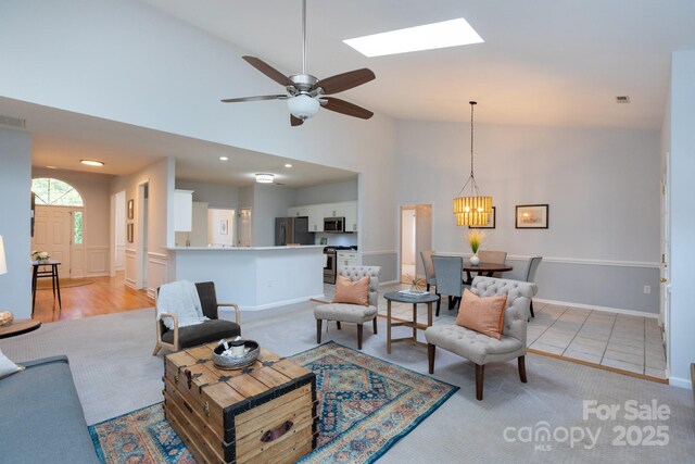 6507 Fairway Point Dr, Charlotte, NC 28269 - living room with light carpet, a ceiling fan, a skylight, high vaulted ceiling, and a chandelier