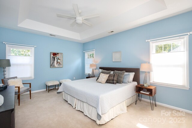 6507 Fairway Point Dr, Charlotte, NC 28269 - bedroom with a raised ceiling, multiple windows, light colored carpet, and a ceiling fan