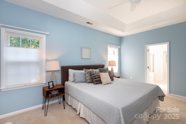 6507 Fairway Point Dr, Charlotte, NC 28269 - bedroom with light carpet, a tray ceiling, a ceiling fan, and connected bathroom
