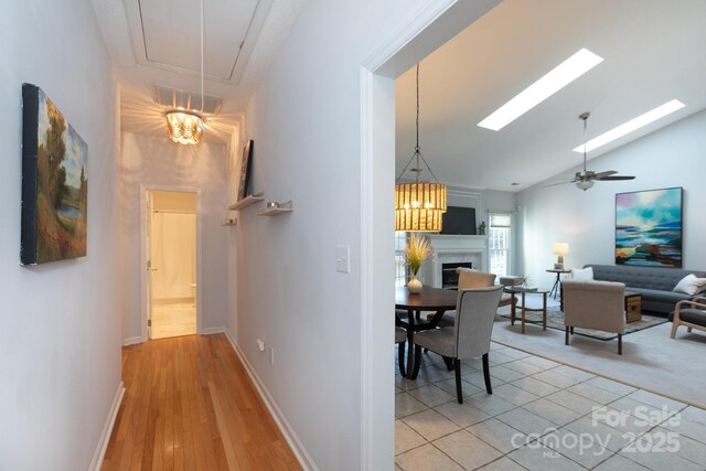 6507 Fairway Point Dr, Charlotte, NC 28269 - corridor featuring high vaulted ceiling, a skylight, attic access, and light wood-style flooring