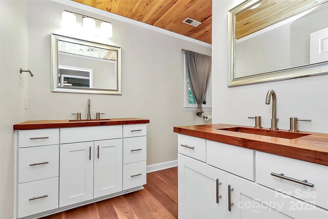 3730 Monique Ln, Charlotte, NC 28210 - bathroom with two vanities, wood ceiling, wood finished floors, and ornamental molding