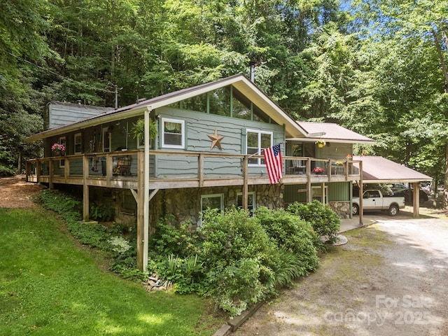 13884 Cruso Rd, Canton, NC 28716 - view of front facade with stone siding, dirt driveway, a carport, and a view of trees