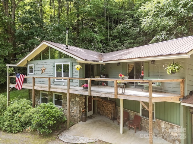 13884 Cruso Rd, Canton, NC 28716 - rear view of house featuring stone siding, a patio, a metal roof, and a view of trees