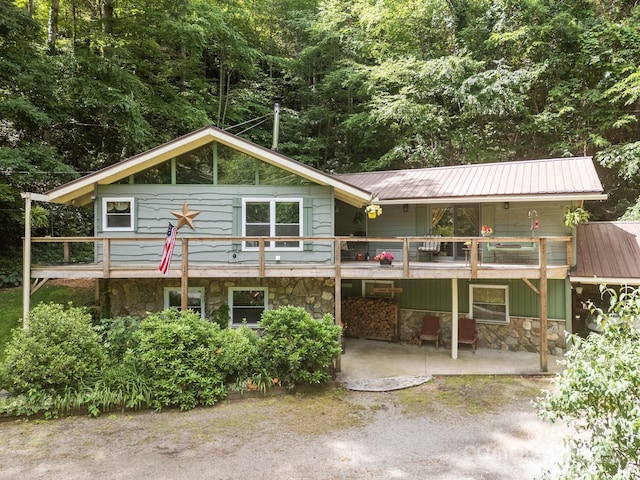 13884 Cruso Rd, Canton, NC 28716 - rear view of house featuring stone siding, a patio area, and a metal roof