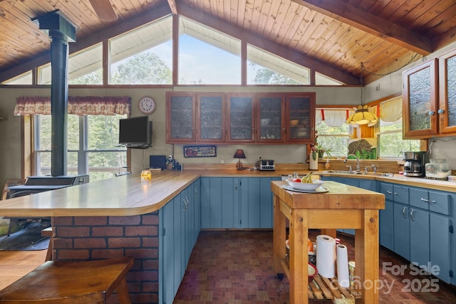 13884 Cruso Rd, Canton, NC 28716 - kitchen with blue cabinets, a peninsula, decorative light fixtures, wood ceiling, and glass insert cabinets