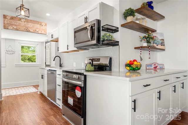 124 Marion St, Clover, SC 29710 - kitchen with appliances with stainless steel finishes, open shelves, light wood-type flooring, light countertops, and white cabinetry
