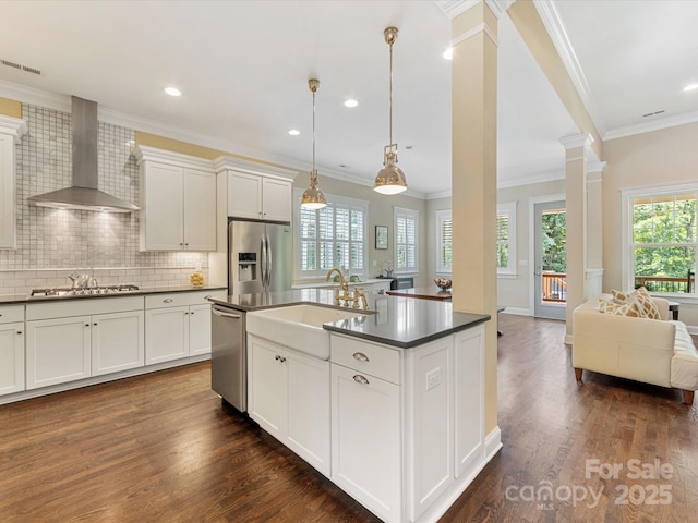 612 Ideal Way, Charlotte, NC 28203 - kitchen featuring wall chimney range hood, appliances with stainless steel finishes, decorative columns, dark countertops, and open floor plan