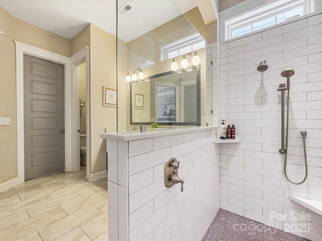 612 Ideal Way, Charlotte, NC 28203 - bathroom with a tile shower, vanity, and marble look tile flooring