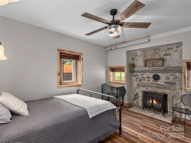 14715 Cruso Rd, Canton, NC 28716 - bedroom with wood finished floors, multiple windows, a ceiling fan, and a fireplace with flush hearth