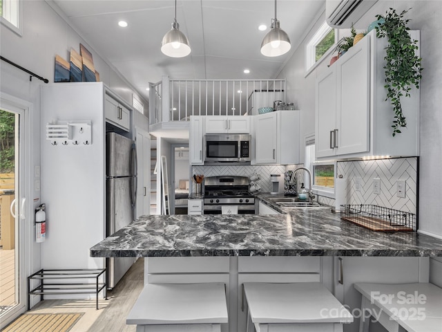 14715 Cruso Rd, Canton, NC 28716 - kitchen featuring stainless steel appliances, a peninsula, backsplash, light wood-style flooring, and plenty of natural light