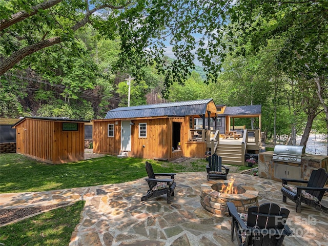 14715 Cruso Rd, Canton, NC 28716 - rear view of property featuring an outdoor fire pit, board and batten siding, a patio area, a lawn, and a metal roof