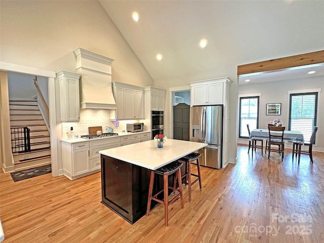 4282 Brandy Creek Ct, Clover, SC 29710 - kitchen featuring stainless steel appliances, a kitchen bar, light countertops, a center island, and backsplash