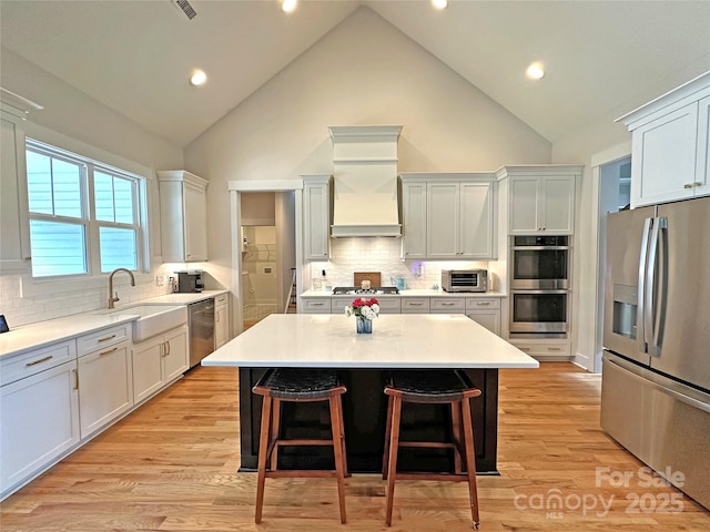 4282 Brandy Creek Ct, Clover, SC 29710 - kitchen with appliances with stainless steel finishes, a breakfast bar, high vaulted ceiling, decorative backsplash, and light countertops