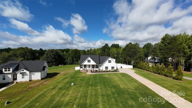 4282 Brandy Creek Ct, Clover, SC 29710 - modern farmhouse style home featuring driveway, a front yard, a forest view, a porch, and an outbuilding