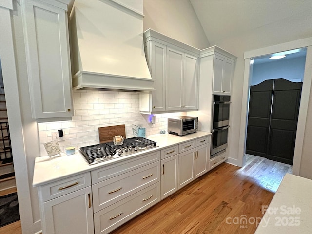 4282 Brandy Creek Ct, Clover, SC 29710 - kitchen with premium range hood, stainless steel appliances, light wood-style floors, light countertops, and lofted ceiling