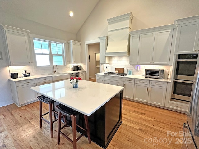 4282 Brandy Creek Ct, Clover, SC 29710 - kitchen with appliances with stainless steel finishes, a kitchen breakfast bar, tasteful backsplash, light countertops, and high vaulted ceiling