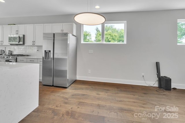 1933 W Trade St, Charlotte, NC 28216 - kitchen with appliances with stainless steel finishes, wood finished floors, backsplash, recessed lighting, and white cabinetry