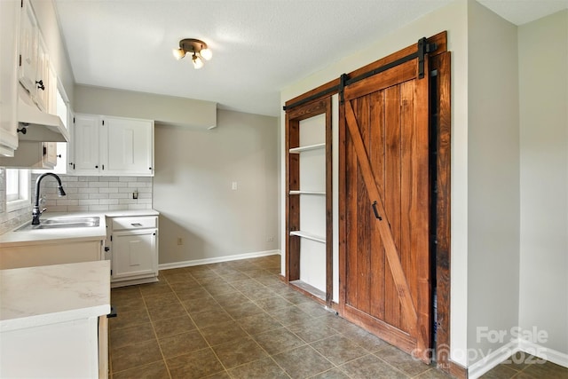 3404 Sheely Rd, Lenoir, NC 28645 - kitchen with decorative backsplash, white cabinets, and a barn door