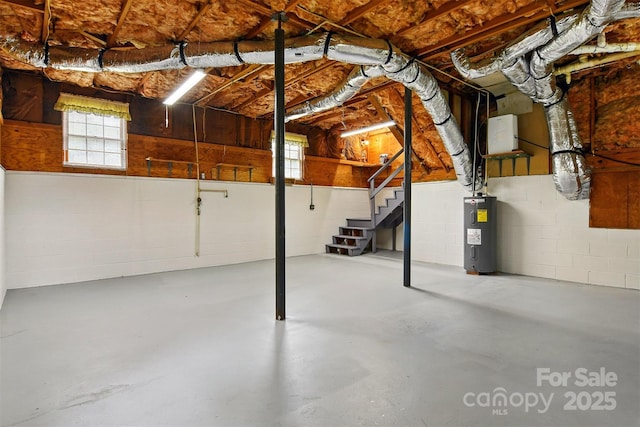 3404 Sheely Rd, Lenoir, NC 28645 - basement featuring electric water heater, stairs, concrete block wall, and plenty of natural light