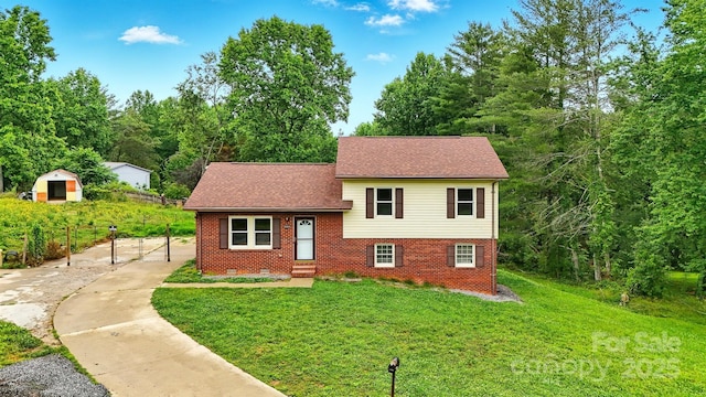 3404 Sheely Rd, Lenoir, NC 28645 - view of front of house featuring brick siding, a front lawn, roof with shingles, and an outbuilding