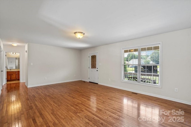1011 Atherstone St NW, Conover, NC 28613 - unfurnished living room featuring hardwood / wood-style floors and baseboards
