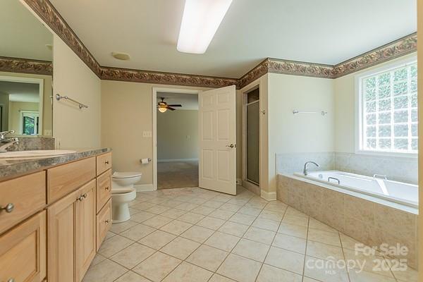 639 Panther Point Trl, Richfield, NC 28137 - full bath with vanity, tile patterned flooring, a garden tub, a stall shower, and ceiling fan