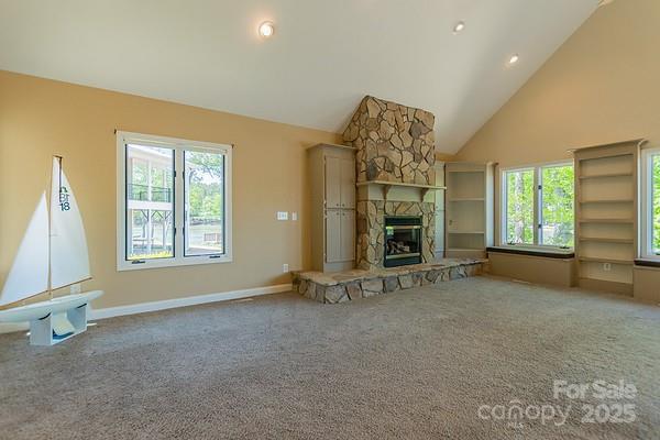 639 Panther Point Trl, Richfield, NC 28137 - unfurnished living room with healthy amount of natural light, carpet flooring, a fireplace, and high vaulted ceiling