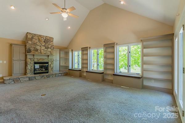 639 Panther Point Trl, Richfield, NC 28137 - unfurnished living room with high vaulted ceiling, carpet, a ceiling fan, a fireplace, and recessed lighting