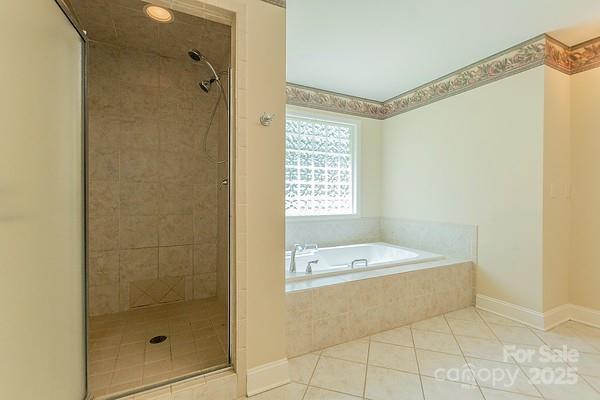 639 Panther Point Trl, Richfield, NC 28137 - bathroom featuring tile patterned flooring, a bath, and a stall shower