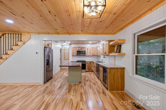 327 Flat Ridge Dr, Lake Toxaway, NC 28774 - kitchen featuring appliances with stainless steel finishes, light wood finished floors, brown cabinets, open shelves, and wine cooler