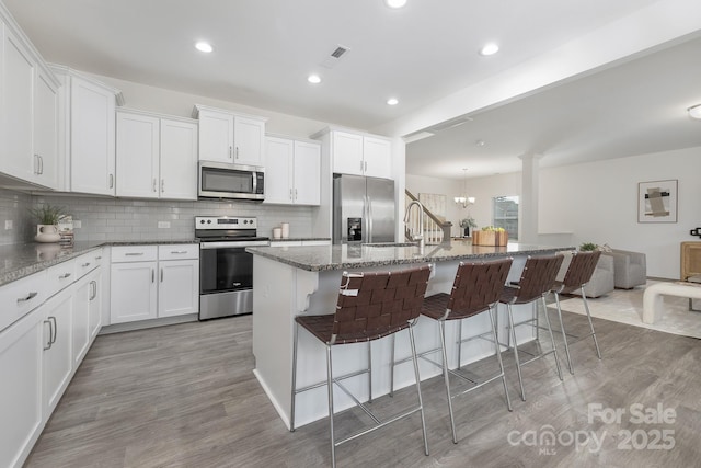 4060 Beacon Ave Unit 148, Monroe, NC 28110 - kitchen featuring stainless steel appliances, a kitchen bar, light wood-type flooring, backsplash, and recessed lighting