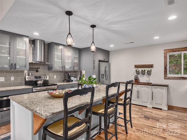 505 Scenic Cir, Waynesville, NC 28786 - kitchen with appliances with stainless steel finishes, wall chimney range hood, gray cabinets, tasteful backsplash, and light wood-style floors
