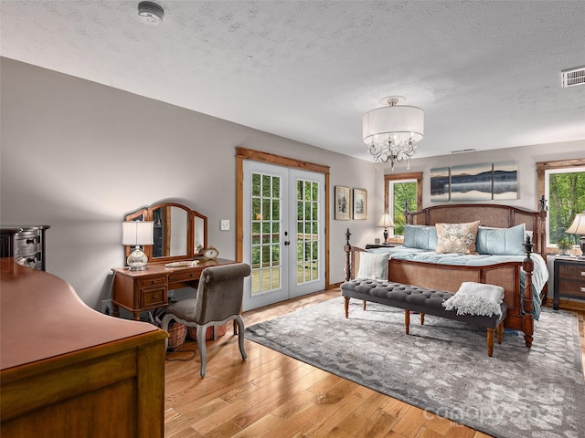 505 Scenic Cir, Waynesville, NC 28786 - bedroom with access to outside, light wood-style flooring, a chandelier, french doors, and a textured ceiling