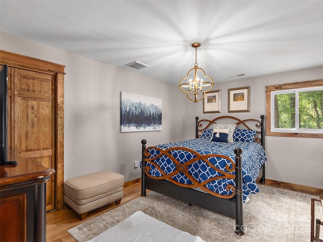 505 Scenic Cir, Waynesville, NC 28786 - bedroom featuring a chandelier and light wood-style floors