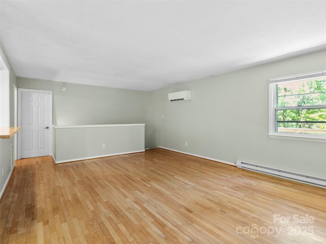 45 Avondale Heights Rd, Asheville, NC 28803 - empty room with light wood finished floors, a wall unit AC, and a baseboard radiator