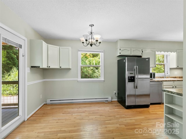 45 Avondale Heights Rd, Asheville, NC 28803 - kitchen featuring stainless steel appliances, baseboard heating, a chandelier, light wood-type flooring, and a textured ceiling