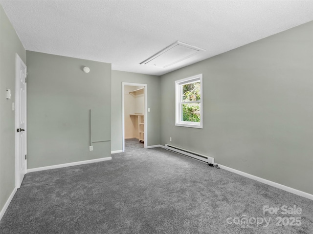 45 Avondale Heights Rd, Asheville, NC 28803 - unfurnished bedroom featuring a baseboard heating unit, attic access, a walk in closet, dark colored carpet, and a closet