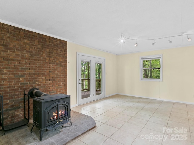 45 Avondale Heights Rd, Asheville, NC 28803 - unfurnished living room featuring a wood stove, light tile patterned floors, track lighting, and crown molding