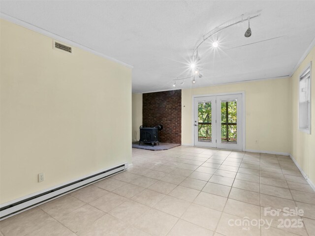 45 Avondale Heights Rd, Asheville, NC 28803 - unfurnished living room with a baseboard heating unit, a wood stove, rail lighting, and light tile patterned floors