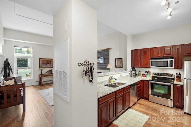 1315 E Blvd Unit 203, Charlotte, NC 28203 - kitchen featuring stainless steel appliances, light wood-style floors, light stone countertops, and dark brown cabinets