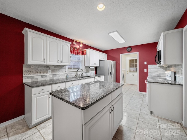 179 Delwood Ct, Mount Gilead, NC 27371 - kitchen featuring stainless steel appliances, backsplash, a textured ceiling, white cabinets, and dark stone counters