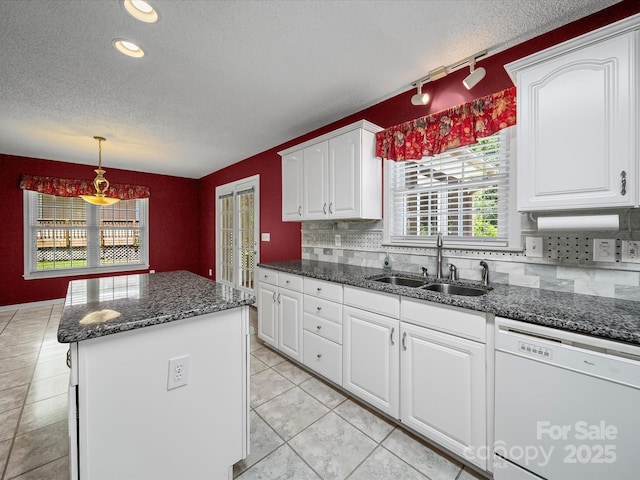 179 Delwood Ct, Mount Gilead, NC 27371 - kitchen featuring dishwasher, rail lighting, a center island, white cabinets, and backsplash