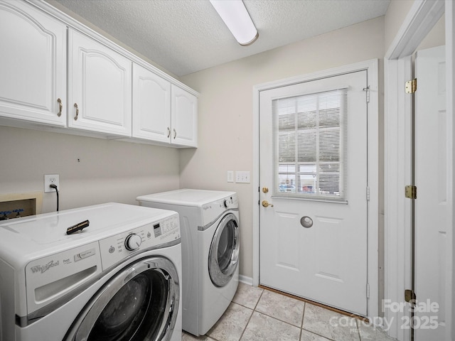 179 Delwood Ct, Mount Gilead, NC 27371 - laundry area featuring washer and dryer, cabinet space, a textured ceiling, and light tile patterned floors
