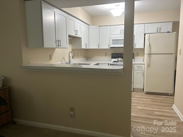 5864 Harris Grove Ln, Charlotte, NC 28212 - kitchen with white appliances, a peninsula, light countertops, light wood-style floors, and white cabinetry