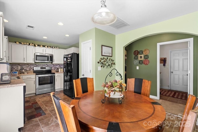 9511 Turning Wheel Dr, Charlotte, NC 28214 - dining space featuring arched walkways, dark tile patterned flooring, and recessed lighting