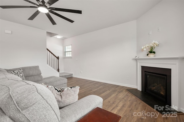 9529 Cotswood Pl, Gastonia, NC 28056 - living room featuring a ceiling fan, wood finished floors, stairs, and a glass covered fireplace