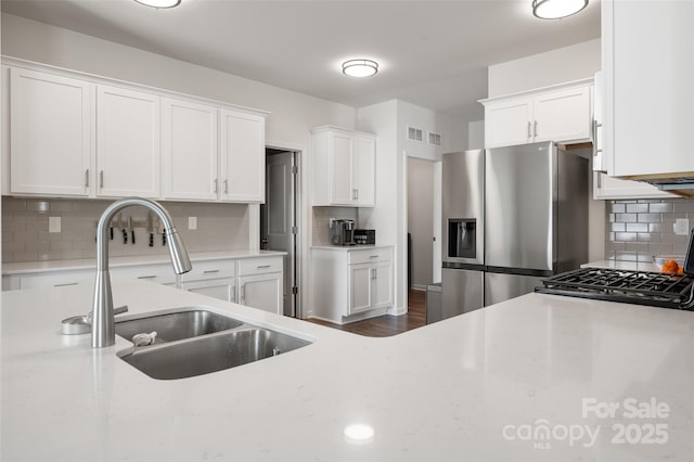 9529 Cotswood Pl, Gastonia, NC 28056 - kitchen with stainless steel fridge with ice dispenser, tasteful backsplash, white cabinetry, stove, and dark wood-style floors